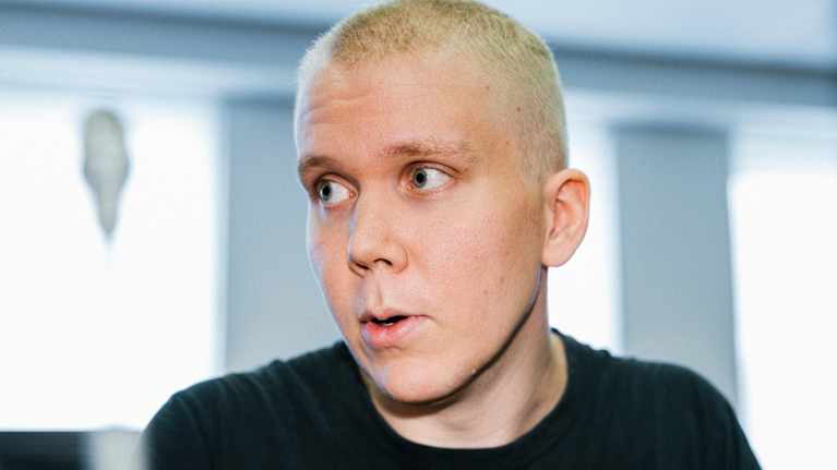Henkilö istuu oikeussalissa.