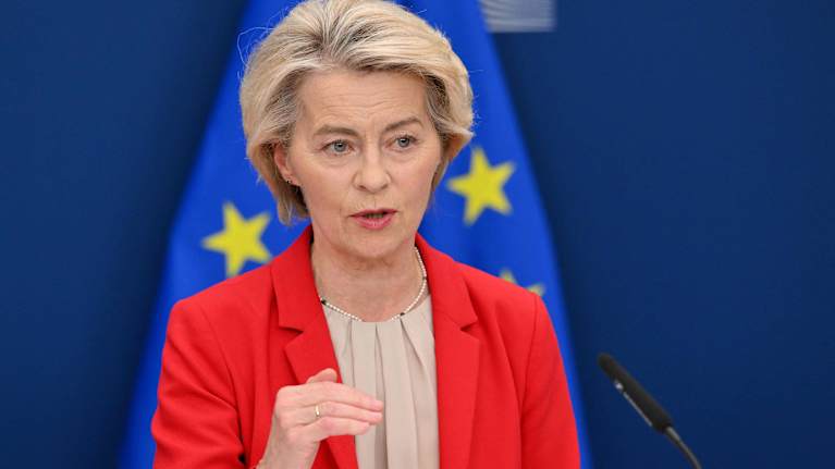 Euroopan komission puheenjohtaja Ursula von der Leyen puhumassa Euroopan unionin tähtilipun edessä.