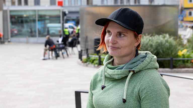 Vihreään huppariin ja mustaan lippikseen pukeutunut Annuska Dal Maso seisoo torilla.