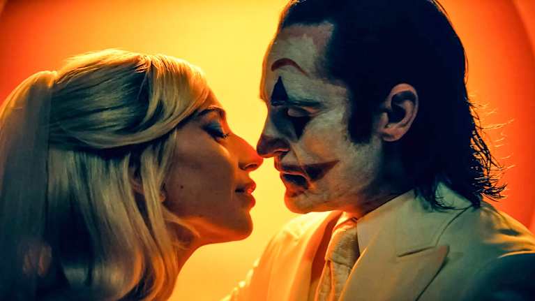 Kohtaus elokuvasta Joker: Folie à Deux, kaksi henkilöä on ryhtymässä suutelemaan, toinen on vaaleahiuksinen, toinen kasvot maalattuina.