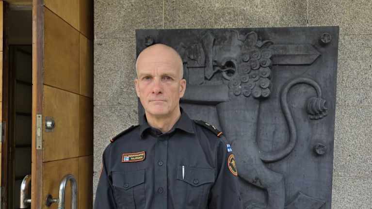 Rajavartiolaitoksen puvussa oleva mies katsoo kameraan.