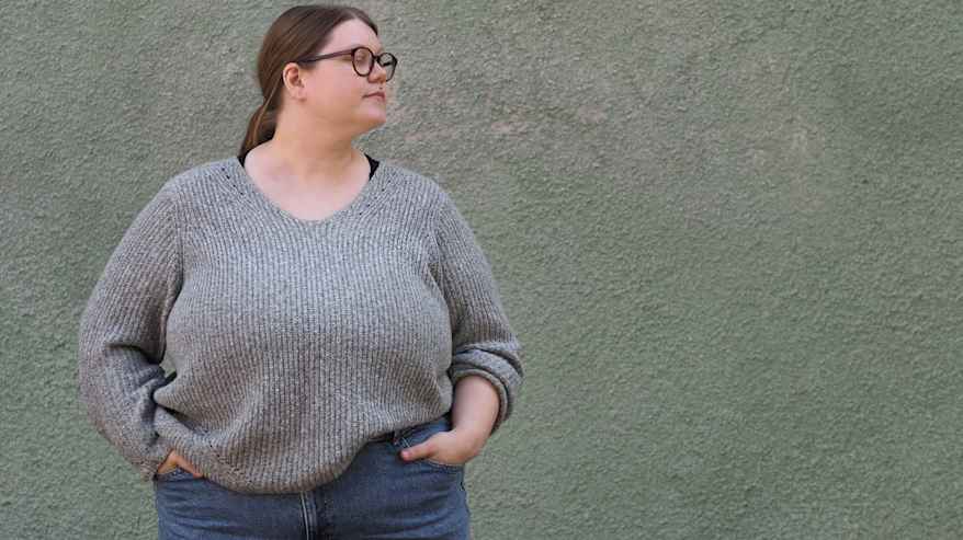 Ida Keränen poseeraa seinää vasten vatsa esillä.