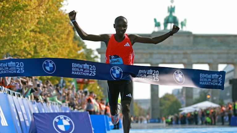 Juoksija ylittää Berliinin maratonin maaliviivan voittajana.