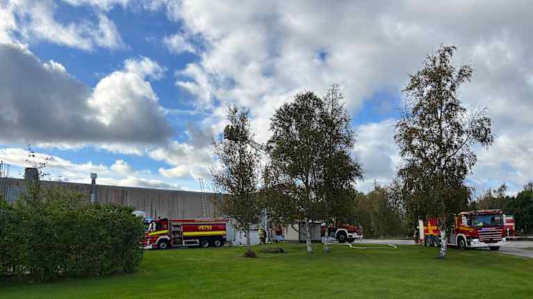 Pelastuslaitoksen ajoneuvoja teollisuusrakennuksen edustalla. Katolle vievät tikkaat on nostettu pystyyn.