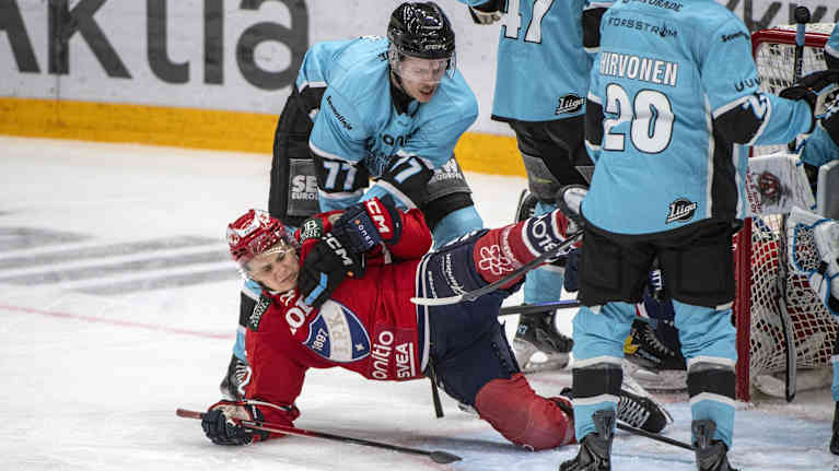 Jääkiekko-ottelussa tapahtuu intensiivinen kamppailu maalin edessä.