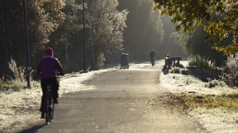 Pappersbron i förmiddags höstljus. Människor cyklar.