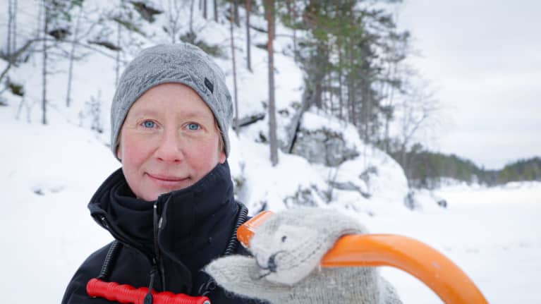 Metsähallituksen erikoissuunnittelija Miina Auttila nojaa lumikolaan Saimaan rantajäällä.
