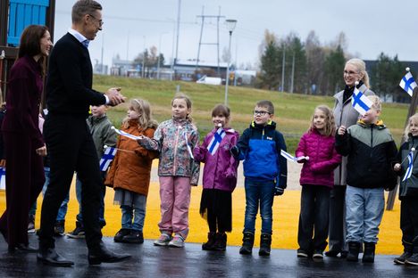 Presidentti Alexander Stubb ja hänen puolisonsa Suzanne Innes-Stubb otettiin vastaan Suomen lippujen kanssa Tuiskulan alakoululla.
