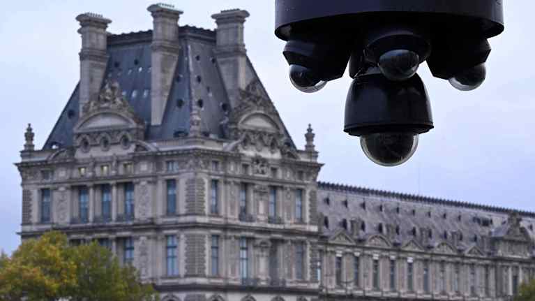 Valvontakamera, taustalla näkyy Louvren taidemuseo sumeana.