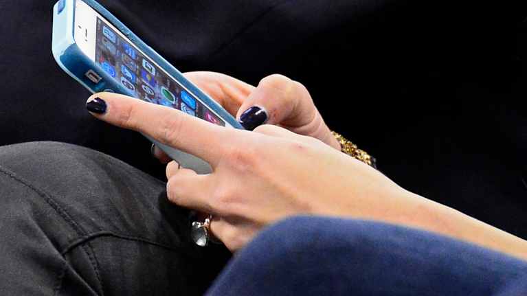 Matkapuhelin käyttäjän kädessä.