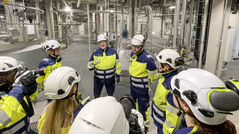 Joukko ihmisiä akkumateriaalien kierrätyslaitoksessa