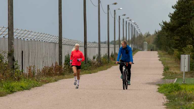 juoksija Alisa Vainio juoksee lenkkiä. Vierellä polkee hänen valmentajansa Jarmo Viskari.