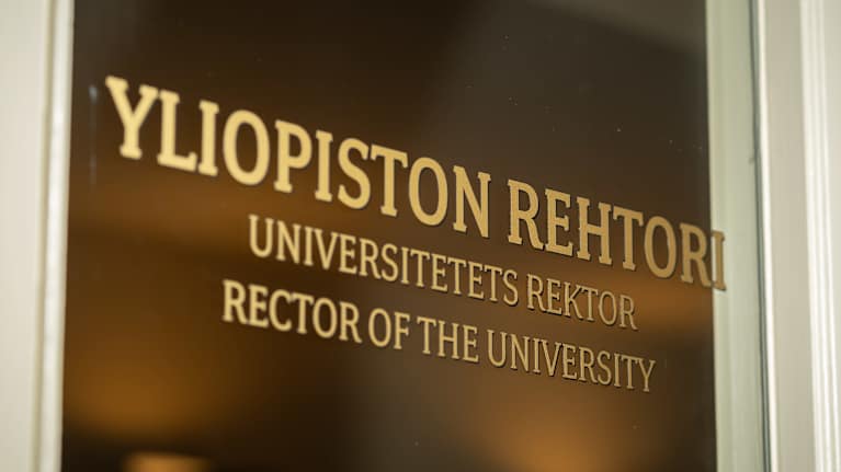 Helsingin yliopiston rehtorin nimikyltti käytävälle johtavassa ovessa.