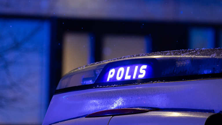 Poliisiauton vilkkuva valokyltti pimeässä yössä.