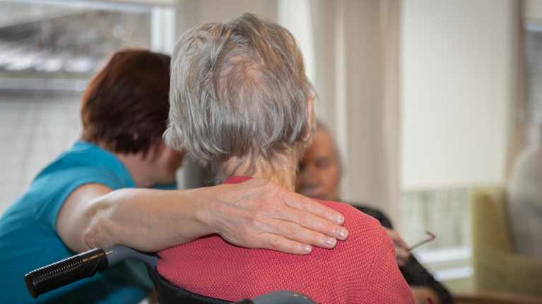 Hoivakodin työntekijä vanhusten kanssa.