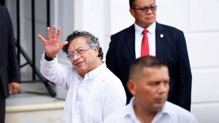 Henkilö katsoo kohti ja vilkuttaa.