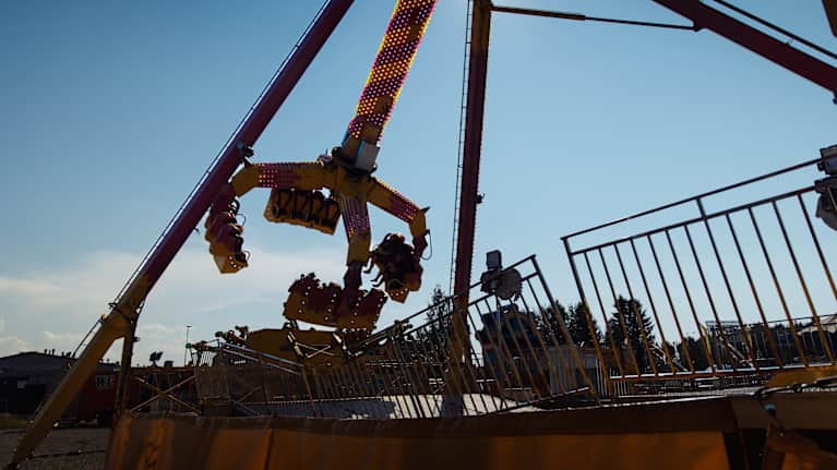 Suomen Tivolissa hurja ja jännittävä huvipuistolaitteiden kiekkokaruselli pyörimässä vauhdikkaasti auringonpaisteessa.