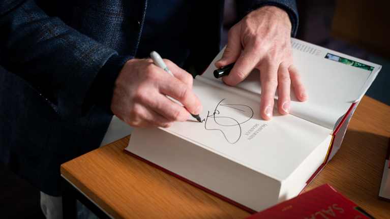 Kirjailija Dan Brown signeeraa kirjansa.