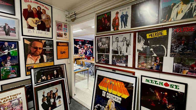 Suomalaisia rokkibändejä ja esiintyjiä seinillä julisteissa.