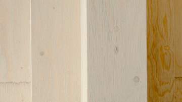 Lähikuva vaaleasta, puunsyykuvioidusta pinnasta, joka koostuu useammasta vierekkäisestä liimapuupalkista.