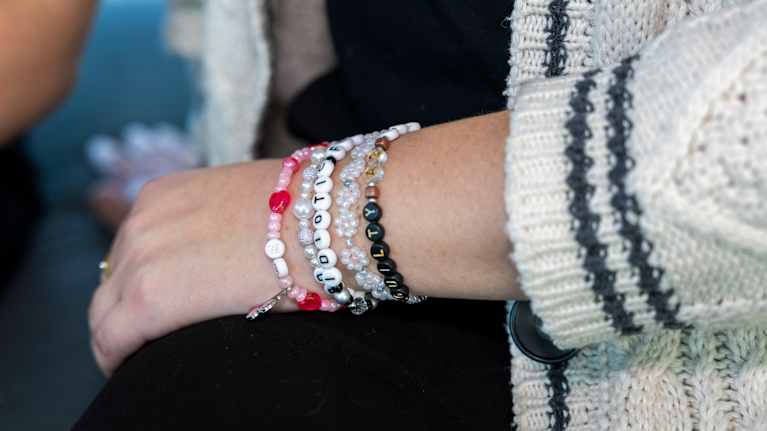 Käsi, jossa on useita persoonallisia helmikoruja.