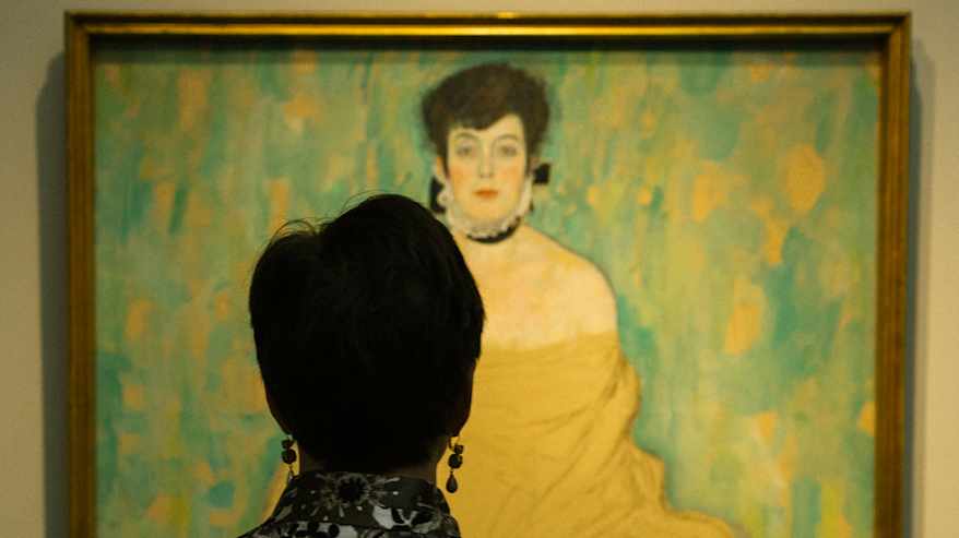 Taidegalleria-kävijä ihailee Gustav Klimtin maalausta.