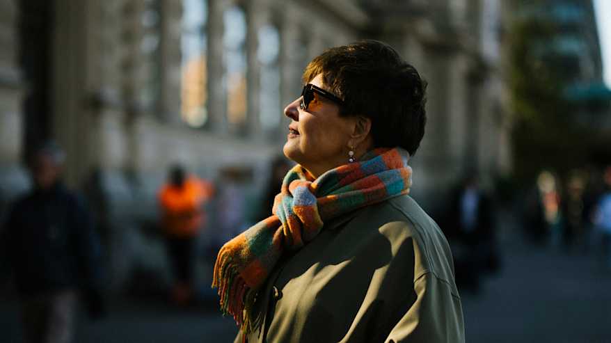 Henkilö seisoo kadulla kaupunkimiljöössä.