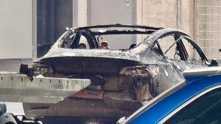 Tulipalossa pahoin vaurioitunut Tesla parkkihallissa.