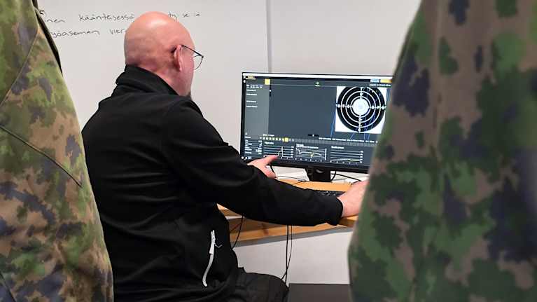 Väitöskirjatutkija Timo Härkönen käyttää sisäampumasimulaattoria Lappeenrannan Maasotakoululla.