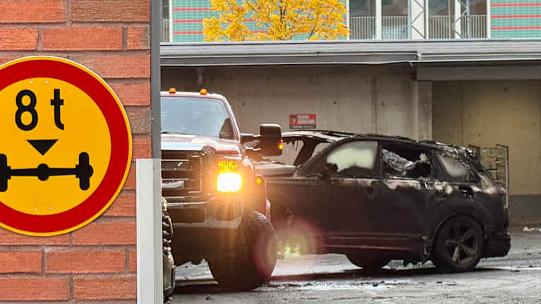 Tampereen parkkihallipalossa tuhoutunutta autoa hinataan katutasolle. 