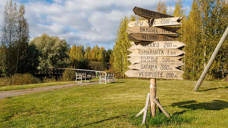 Puusta tehdyt opasteviitat osoittavat Luhangan kirkonkylän palveluiden suunnat ja etäisyydet.