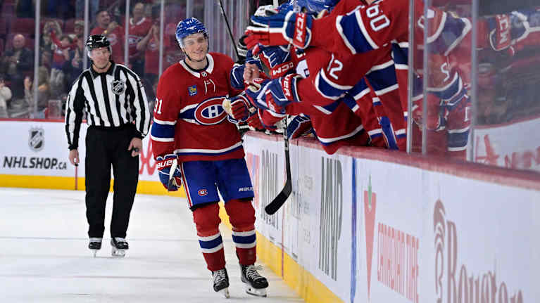 Spelare firar mål framför båset.