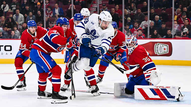 Jääkiekkoilijat kamppailevat kiekosta maalin edessä.