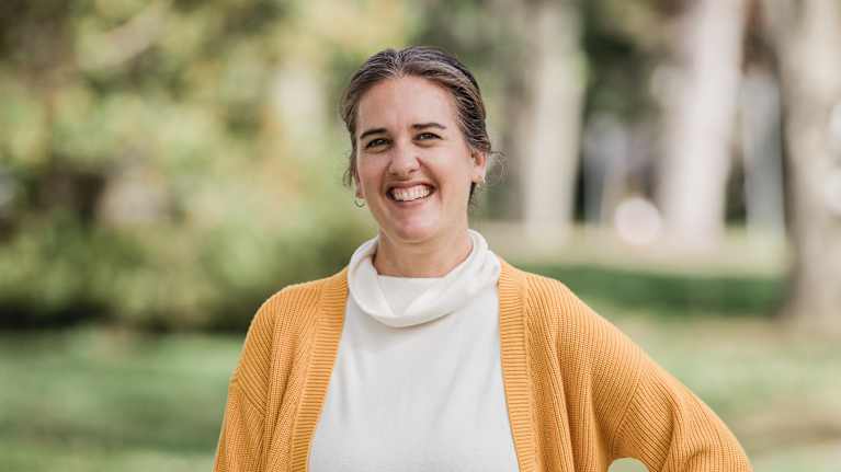 Laurie Gilmore seisoo polulla keltainen villatakki päällään.