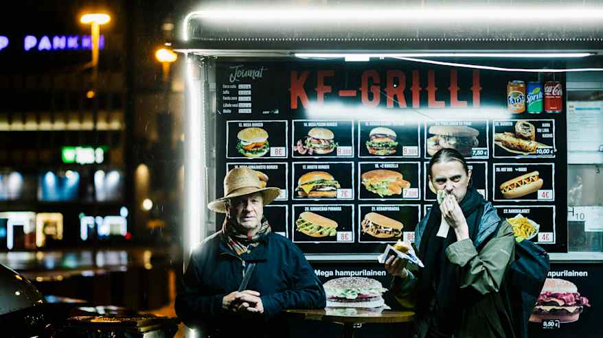 Kaksi henkilöä seisoo yöllä liikkuvan grillin edessä