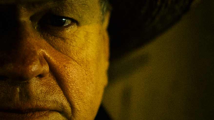 Henkilö, jolla on leveälierinen hattu ja huivi kaulassaan.