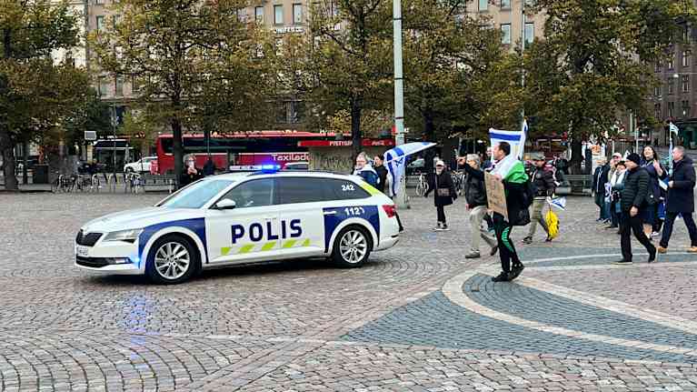 Poliisiauto mielenosoituskulkueen keulalla Helsingissä.