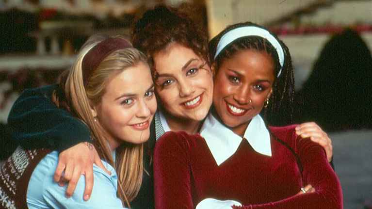 Clueless- elokuvan kolme nuorta naispäähenkilöä yhdessä, he hymyilevät ja ovat pukeutuneina tyylikkäisiin asuihin.