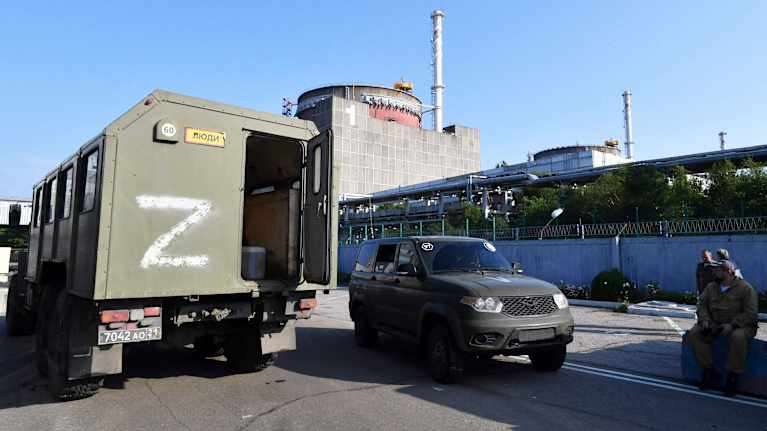Kirjaimella Z merkattu sotilasajoneuvo ydinvoimalarakennuksen vieressä.