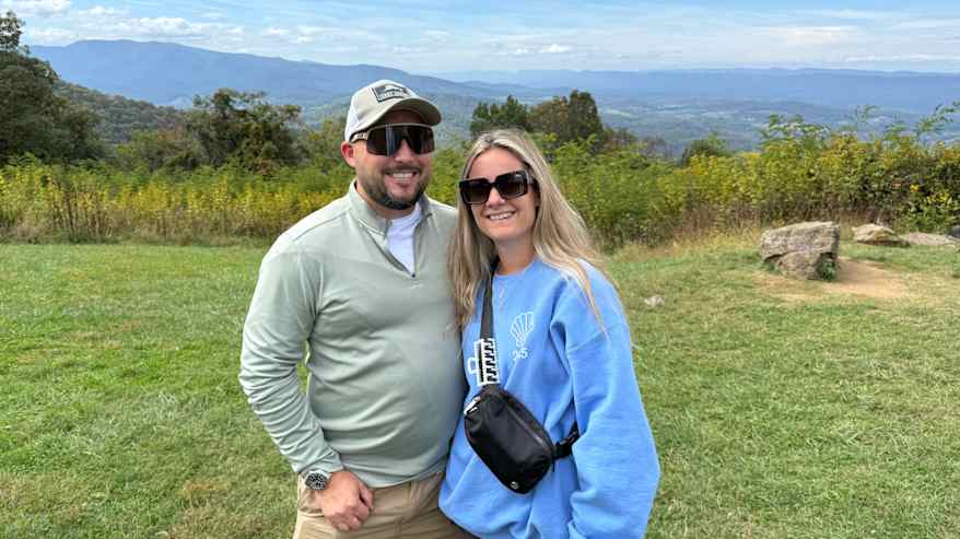 Mies ja nainen katsovat kameraan kansallispuistossa.