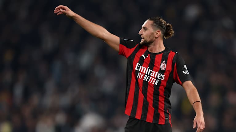 Jalkapalloilija mustapunaisessa pelipaidassa.