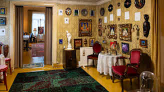 Matti Rag Paanasen taiteilijakodin aula. Seinillä paljon maalauksia. 