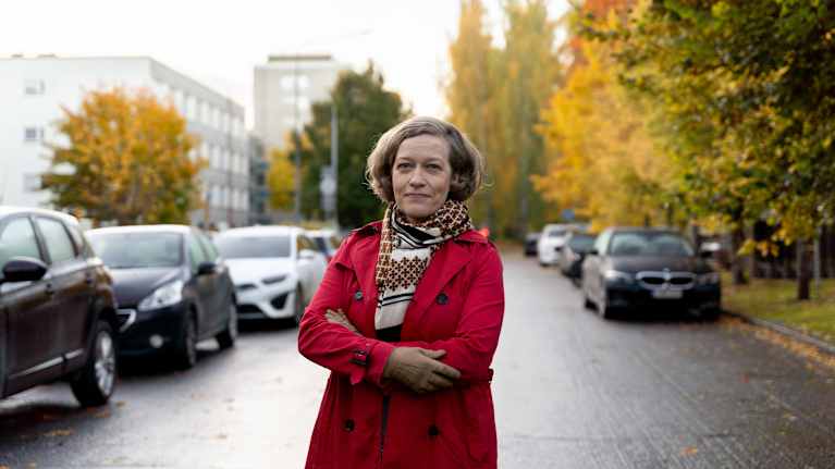 Nainen syksyisessä kaupunkimaisemassa.