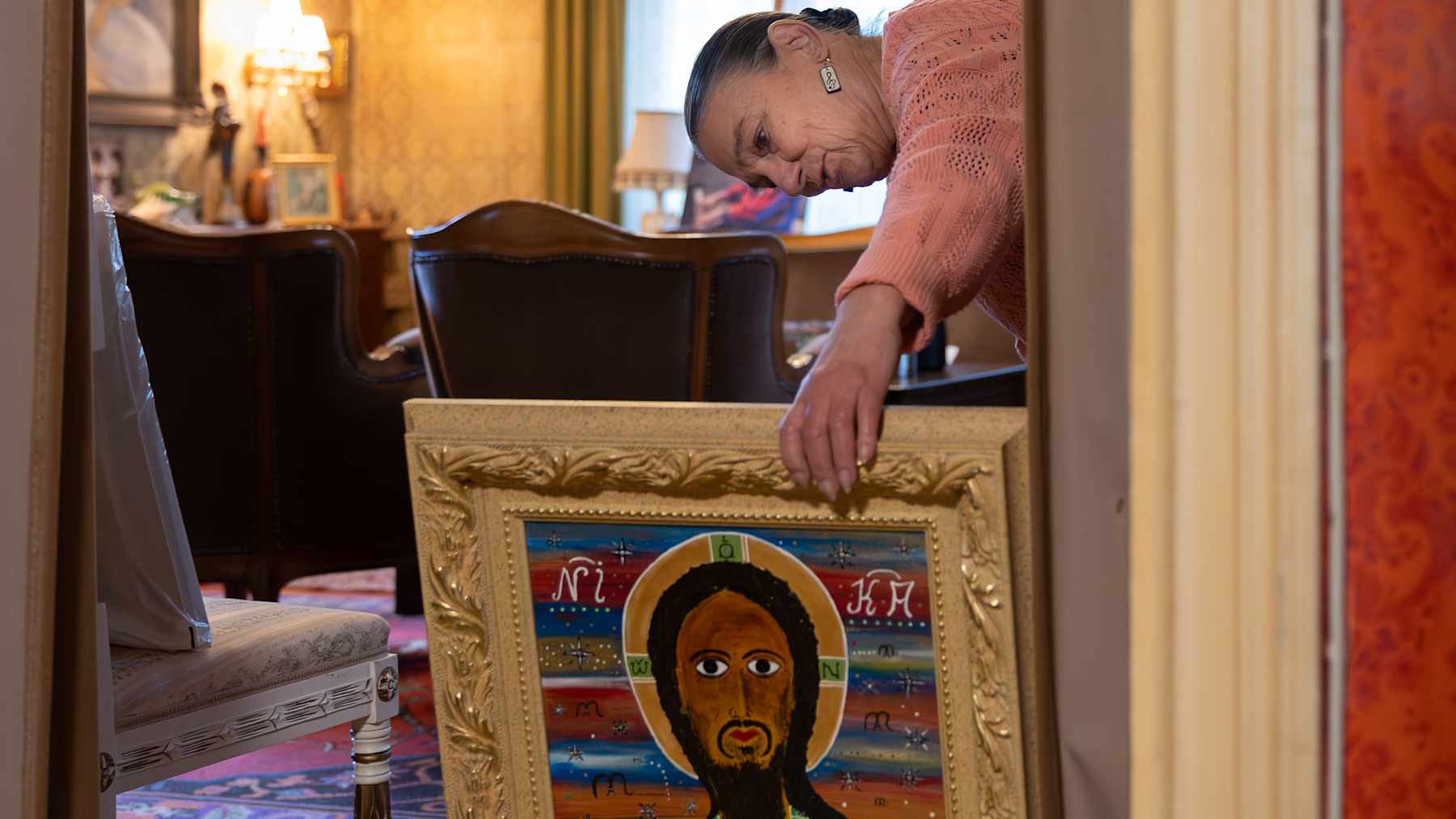 Ammi Paananen tutkailee puolisonsa Matti Rag Paanasen työn "Antikoni X, Ylösnousemus" (2017) takapuolella olevia tietoja. 