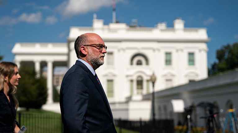 Russell Vought, kalju harmaapartainen mies, kävelee Valkoisen talon ohi.