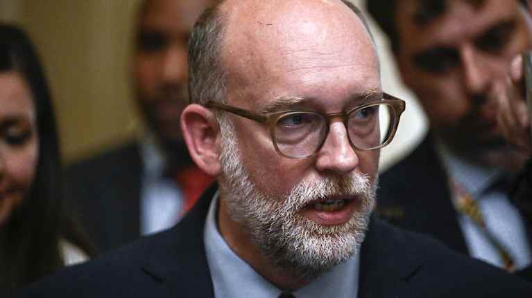 Lähikuvassa Russell Vought, harmaa trimmattu parta, kalju ja silmälasit.