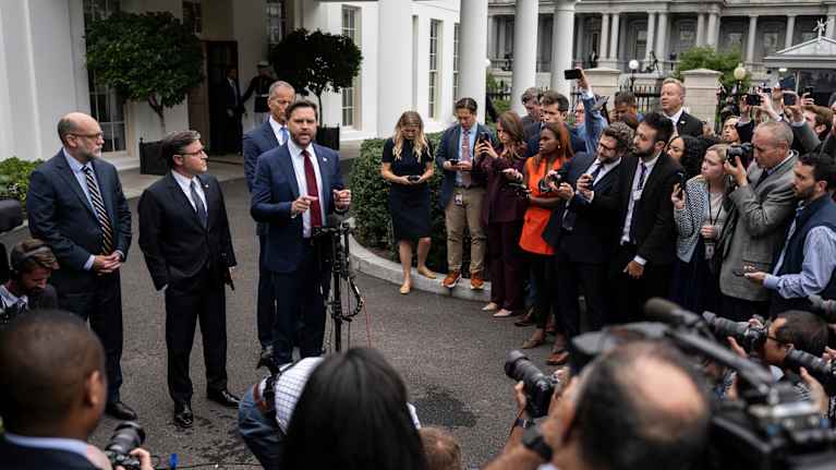 Varapresidentti Vance puhuu, kuvan vasemmassa reunassa Russell Vought, toimittajat seuraa, Valkoisen talon edustalla.