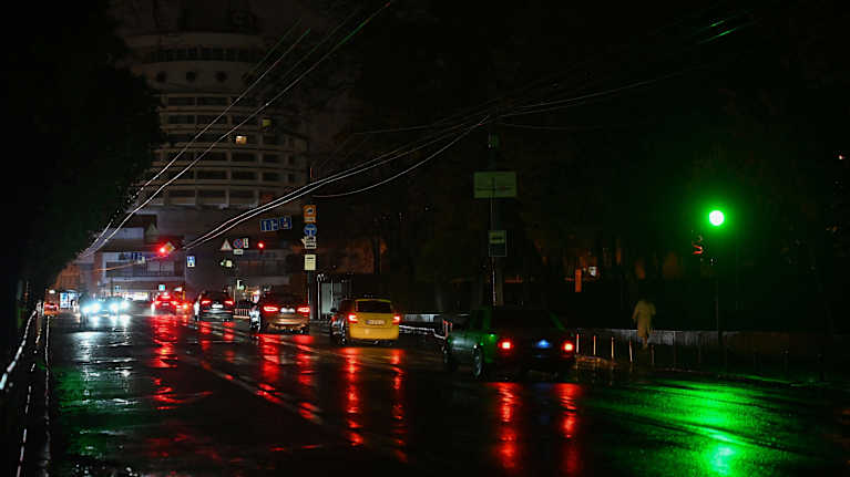Autojen valot valaisevat sähkökatkon pimentämää Kiovaa.