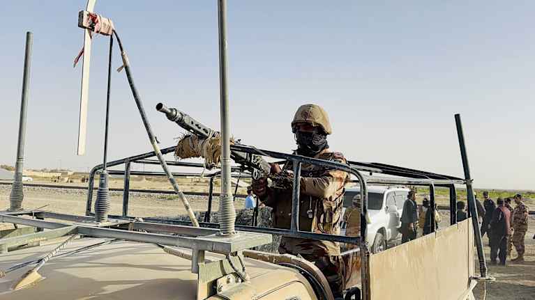 Pakistanilainen sotilas ajoneuvon lavalla konekiväärin kanssa.