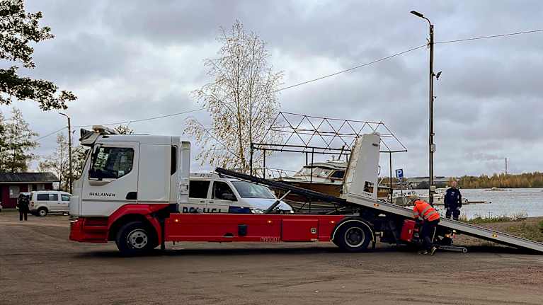 Hinausauto ja poliiseja venesatamassa.